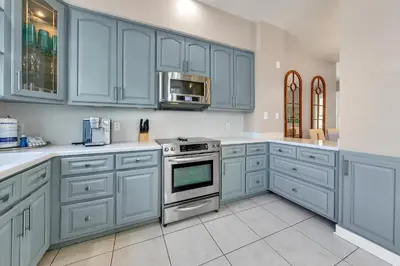 a kitchen with blue cabinets and a stove at Relax Awhile in Panama City Beach