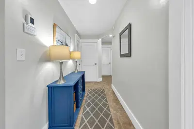 a hallway with a blue cabinet and a lamp on it at Relax Awhile in Panama City Beach