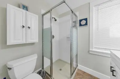 a bathroom with a glass shower stall and a toilet at Relax Awhile in Panama City Beach