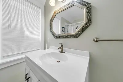 a white bathroom with a sink and a mirror at Relax Awhile in Panama City Beach