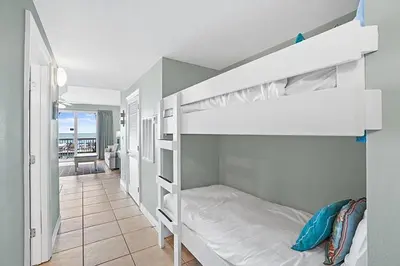 a bedroom with two bunk beds and a balcony at Calypso 2-103 West in Panama City Beach