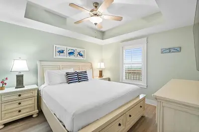 a bedroom with a bed and a ceiling fan at Calypso 3-1011 in Panama City Beach