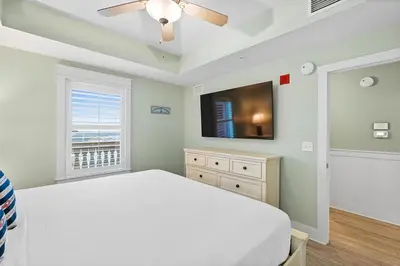 a bedroom with a bed and a flat screen tv at Calypso 3-1011 in Panama City Beach