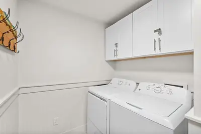 a white laundry room with a washer and dryer at Calypso 3-1011 in Panama City Beach