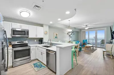 a kitchen and dining room with a view of the ocean at Calypso 3-1011 in Panama City Beach