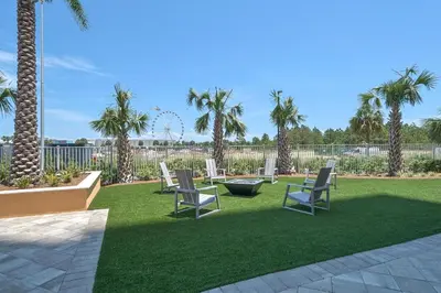 a lawn with chairs and palm trees in a yard at Calypso 3-1011 in Panama City Beach
