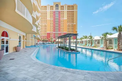 a swimming pool at a resort with a building at Calypso 3-1011 in Panama City Beach