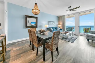 a dining room and living room with a table and chairs at Aqua Resort 905 by Emerald Coast Retreats in Panama City Beach