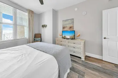 a bedroom with a bed and a tv on a dresser at Aqua Resort 905 by Emerald Coast Retreats in Panama City Beach