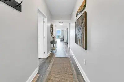 a hallway with white walls and a rug at Aqua Resort 905 by Emerald Coast Retreats in Panama City Beach
