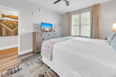 a bedroom with a bed and a dresser with a tv at Aqua Resort 905 by Emerald Coast Retreats in Panama City Beach