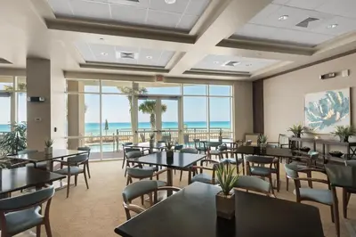 a restaurant with tables and chairs and a view of the ocean at Aqua Resort 905 by Emerald Coast Retreats in Panama City Beach