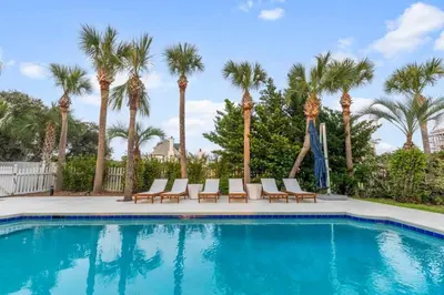 a swimming pool with chairs and palm trees at Happy to Sea You, Beach Access, Private Pool, Yard, Patio, Deck in Inlet Beach