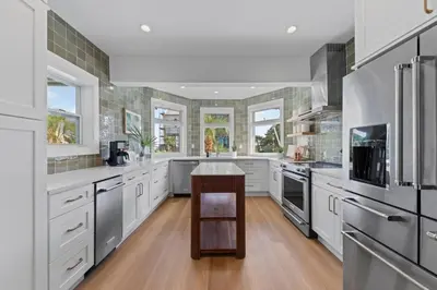 a large kitchen with white cabinets and a table at Happy to Sea You, Beach Access, Private Pool, Yard, Patio, Deck in Inlet Beach
