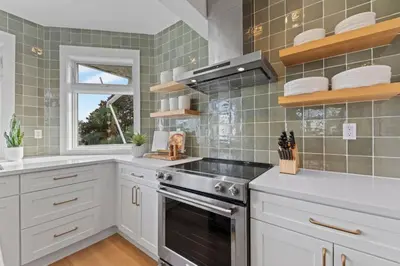 a kitchen with white cabinets and a stove at Happy to Sea You, Beach Access, Private Pool, Yard, Patio, Deck in Inlet Beach