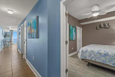 a bedroom with a bed and a blue wall at Stunning Beachfront Condo, Walk to Pier Park,Pools in Panama City Beach