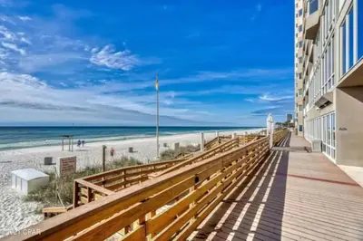 a boardwalk leading to the beach at a resort at Stunning Beachfront Condo, Walk to Pier Park,Pools in Panama City Beach