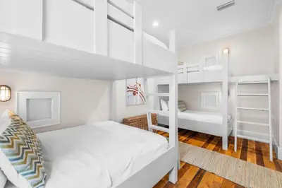 a white bedroom with a bunk bed and a ladder at One Second Away in Santa Rosa Beach