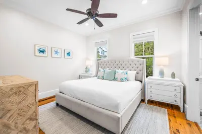 a white bedroom with a bed and a ceiling fan at One Second Away in Santa Rosa Beach