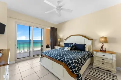 a bedroom with a bed and a view of the ocean at Treasure Island #0309 in Panama City Beach
