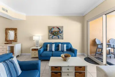 a living room with a blue couch and a table at Treasure Island #0309 in Panama City Beach