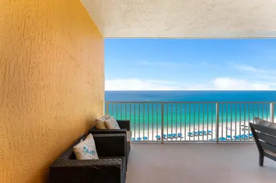 a room with a balcony with a view of the ocean at Treasure Island #0607 in Panama City Beach
