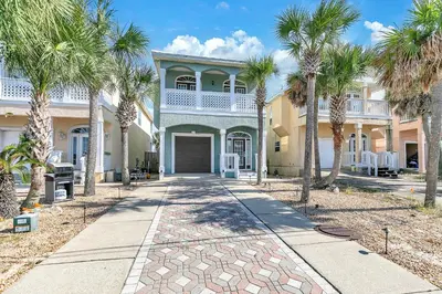 a house with palm trees in front of it at Seaside Serenity in Panama City Beach