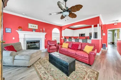 a living room with red walls and a red couch at Seaside Serenity in Panama City Beach