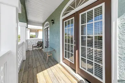 a home with a porch with sliding glass doors at Seaside Serenity in Panama City Beach