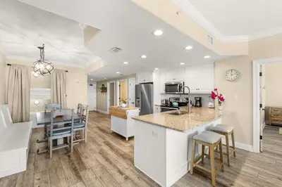 an open kitchen and living room with a dining area and a counter top at Treasure Island #1108 in Panama City Beach