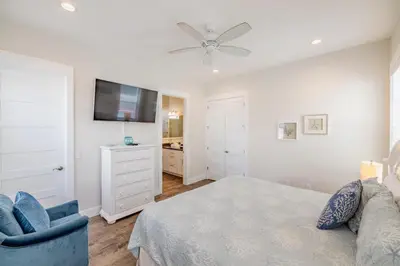 a bedroom with a bed and a tv and a chair at Southern Breeze - Private Pool - 100 Feet From The Beach! in Panama City Beach