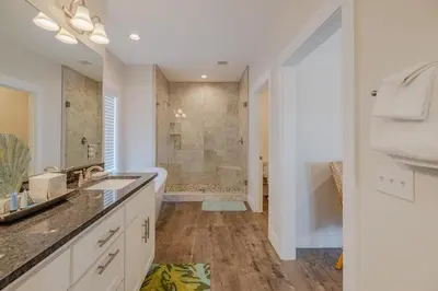 a bathroom with a shower and a sink and a tub at Southern Breeze - Private Pool - 100 Feet From The Beach! in Panama City Beach