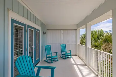 two blue chairs on a porch with a view of the ocean at Southern Breeze - Private Pool - 100 Feet From The Beach! in Panama City Beach