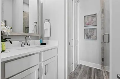 a white bathroom with a sink and a mirror at Luxury Breeze - Luxury Home With Private Pool & Private Beach! in Panama City Beach