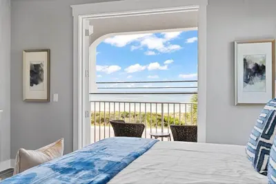 a bedroom with a bed and a view of the ocean at Luxury Breeze - Luxury Home With Private Pool & Private Beach! in Panama City Beach