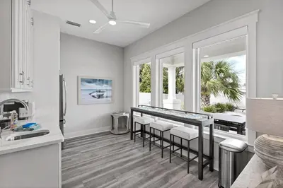 a kitchen with a bar with stools in it at Luxury Breeze - Luxury Home With Private Pool & Private Beach! in Panama City Beach