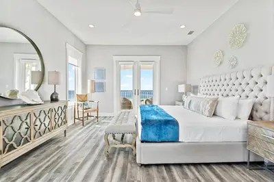 a bedroom with a large bed and a mirror at Luxury Breeze - Luxury Home With Private Pool & Private Beach! in Panama City Beach