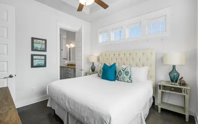 a bedroom with a white bed with blue pillows at 12 Milestone Dr C by Oversee 30A in Inlet Beach
