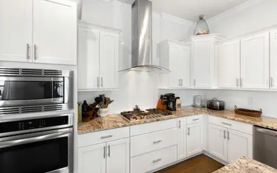 a kitchen with white cabinets and a stove top oven at 310 Grande Pointe by Oversee 30A in Inlet Beach