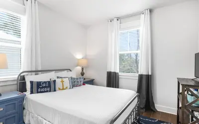 a bedroom with a bed and two windows at 310 Grande Pointe by Oversee 30A in Inlet Beach