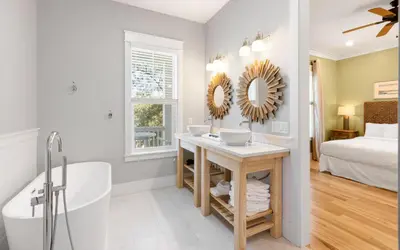 a bathroom with a tub and a sink and a mirror at 91 San Juan by Oversee 30A in Santa Rosa Beach
