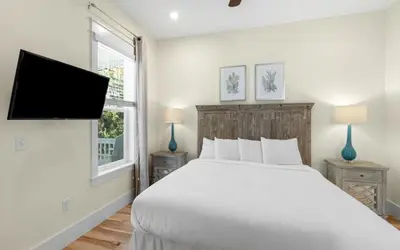a bedroom with a bed and a flat screen tv at 91 San Juan by Oversee 30A in Santa Rosa Beach