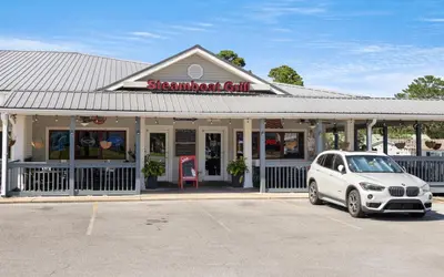 a white car parked in a parking lot in front of a restaurant at 91 San Juan by Oversee 30A in Santa Rosa Beach