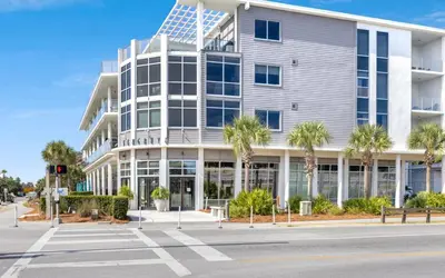 an office building with palm trees in front of it at 91 San Juan by Oversee 30A in Santa Rosa Beach