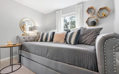 a blue couch in a room with a window at A Hasty Retreat by Oversee 30A in Seagrove Beach