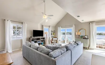a living room with a large couch and a tv at A Hasty Retreat by Oversee 30A in Seagrove Beach