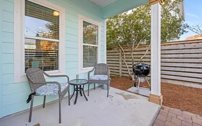 a patio with two chairs and a table and a grill at After Dune Delight by Oversee 30A in Inlet Beach