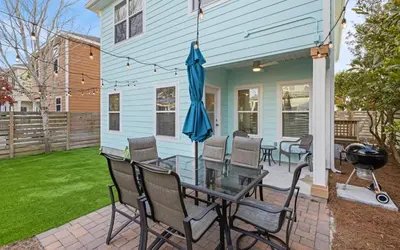 a patio with a glass table and chairs on a house at After Dune Delight by Oversee 30A in Inlet Beach