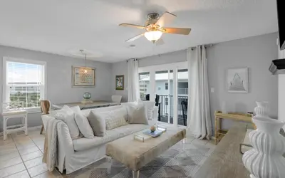 a living room with a white couch and a ceiling fan at Aqua Bella by Oversee 30A in Santa Rosa Beach