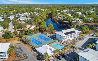 an aerial view of a resort with a tennis court at Aqua Bella by Oversee 30A in Santa Rosa Beach